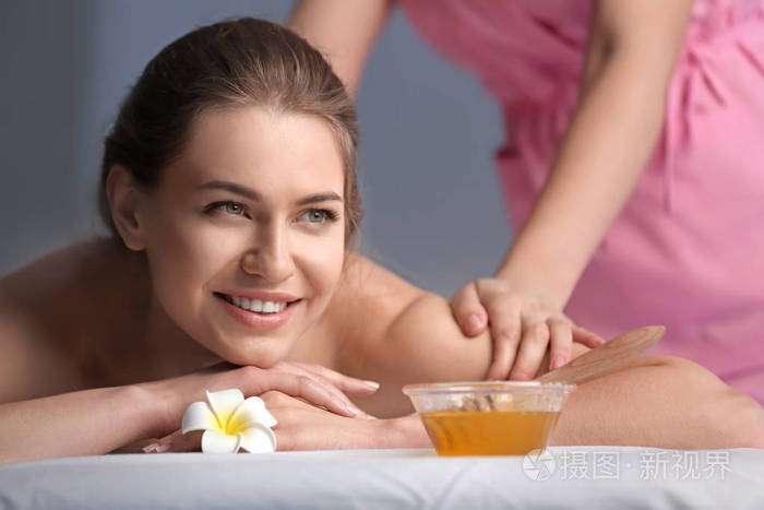 美容沙龙的年轻女子背部按摩