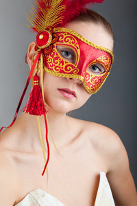 美丽的年轻女子，穿着红色嘉年华面具