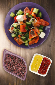 木制背景的希腊沙拉。在一个盘子顶部的看法希腊沙拉。健康食品