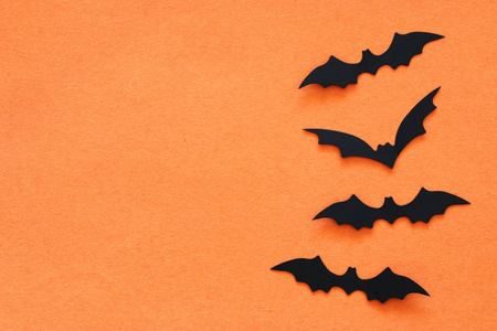 万圣节假期的概念。黑蝙蝠超过橙色背景。顶部视图, 平躺