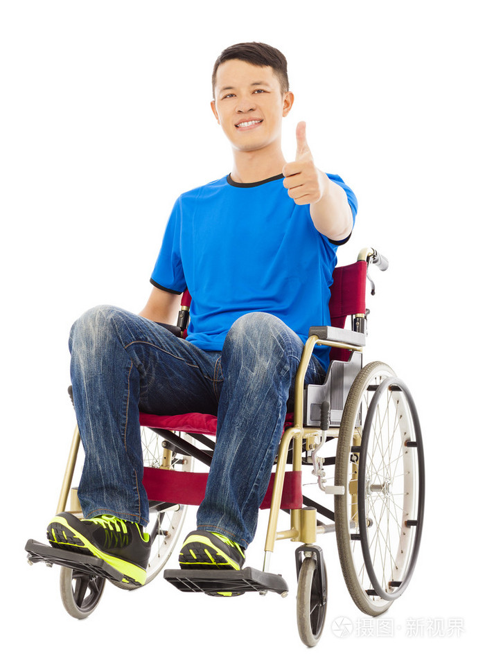 快乐的年轻男子坐在轮椅上和大拇指