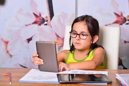 家庭作业使用平板电脑和电子书的小女孩