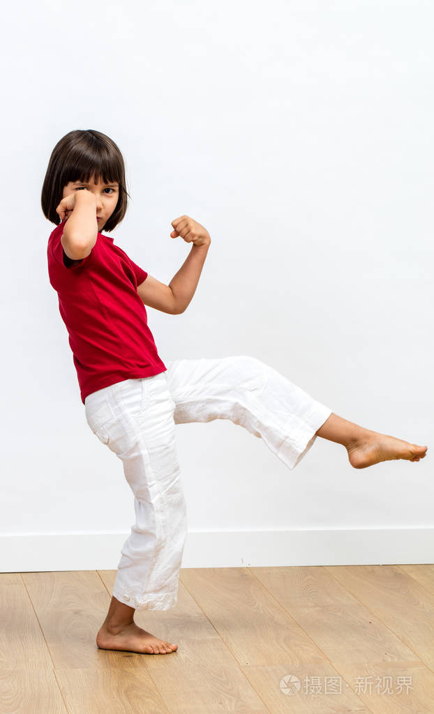 兴奋的小孩子显示她的力量与拳头举起, 享受锻炼武术, 太极, 功夫或