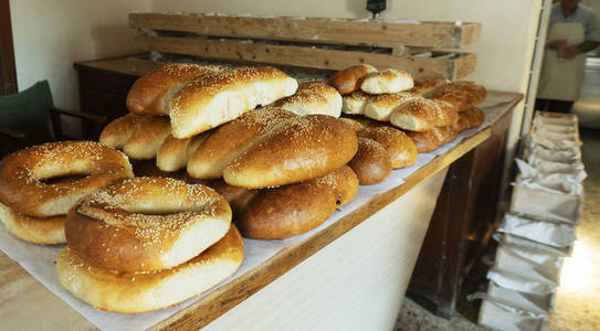 在乡村面包店柜台的新鲜糕点。用面团为烤箱准备的木制模具。地道的乡村美味的面包