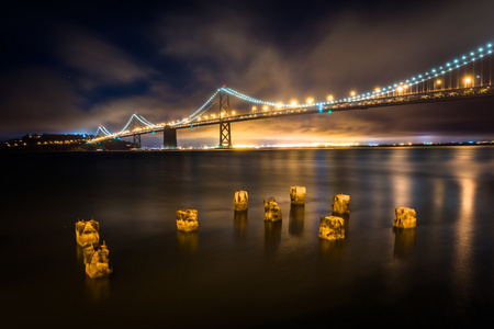 桥墩桩和 San Francisco奥克兰湾大桥夜景