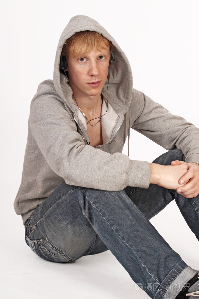 时尚的年轻人坐在地上在白色背景上孤立