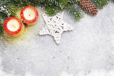 圣诞节装饰, 蜡烛和冷杉树枝覆盖在石头的背景雪。顶部查看圣诞背景与空间为您的问候