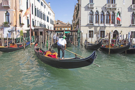 威尼斯船夫在缆车通过意大利威尼斯运河水域运送游客