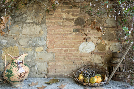 秋季背景。篮子与不同的南瓜, 缺点, 叶子和老式花瓶。庭院装饰。托斯卡纳意大利