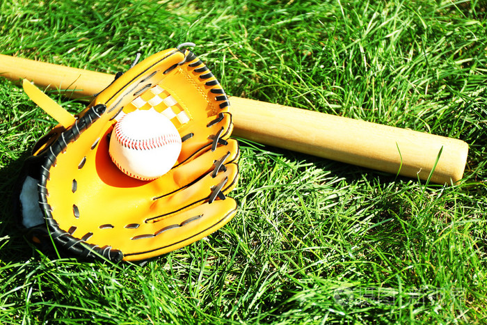 棒球棒球和手套上绿草背景