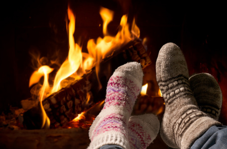气候变暖在壁炉的羊毛袜子的脚图片