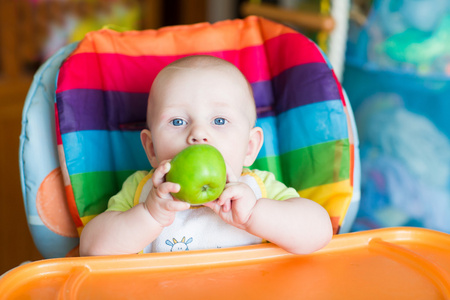 可爱的宝宝吃苹果在高脚椅