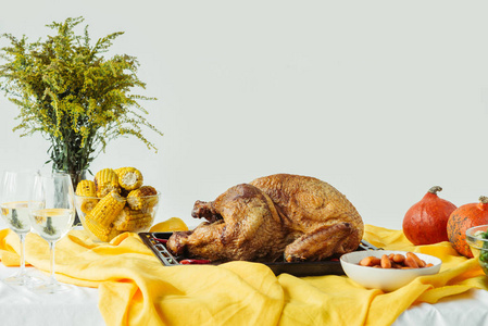 在烤盘葡萄酒和南瓜的表面上, 在灰色的背景上, 用桌布上的美味的火鸡, 感恩节假期的概念关闭视图