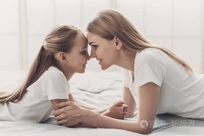 妈妈和孩子在家里躺在床上.家庭和母性概念