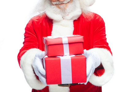 圣诞节。微笑的圣诞老人在白色手套拿着两个礼物红色箱子与弓, 一个在另一边。在白色背景下被隔离。特写