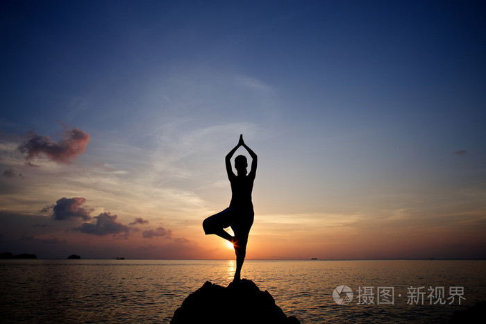 在海滩上的年轻女子冥想瑜伽姿势