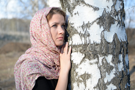 俄罗斯姑娘在一条围巾在白桦林关闭