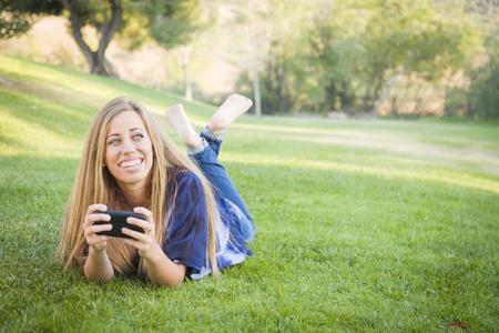 微笑的年轻女士使用手机户外