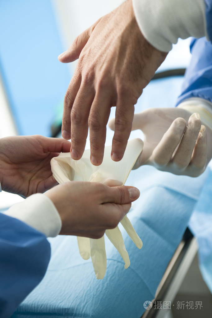 外科医生戴上防护手套