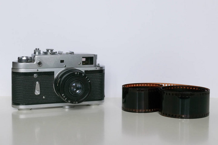 白色背景上带有胶片条纹的旧苏联胶片相机