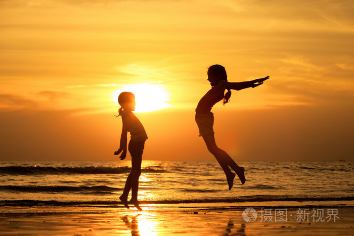 在沙滩上跳跃的快乐女孩
