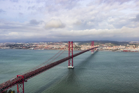 里斯本和 puente 25 de abril 桥梁在多云天, 葡萄牙