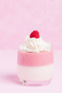 树莓智世陶在柔和的粉红色背景上装饰奶油和成熟的浆果关闭在美丽的眼镜夏季水果甜乳制品甜点的照片