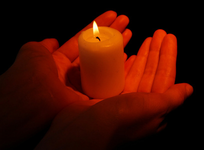 祭祀蜡烛燃烧的蜡烛,在手上黑色孤立照片