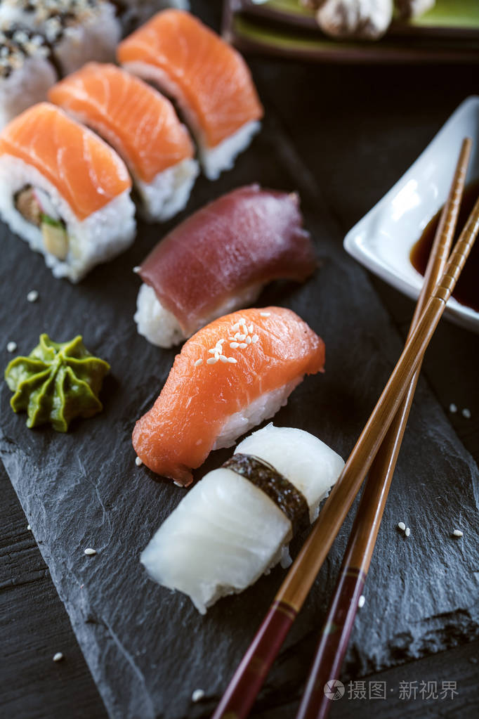 寿司集的生鱼片和寿司卷,送达石石板