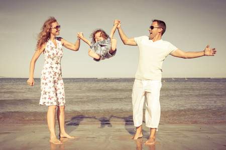 幸福的家庭，在白天的时间在沙滩上散步