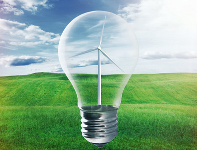 灯泡与风电机组内部在绿色的田野。环境