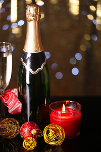 瓶香槟与玻璃和圣诞球圣诞灯背景上