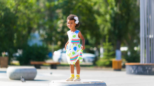 小非洲裔美国女孩在城市广场跳舞.一个快乐的黑人孩子照片