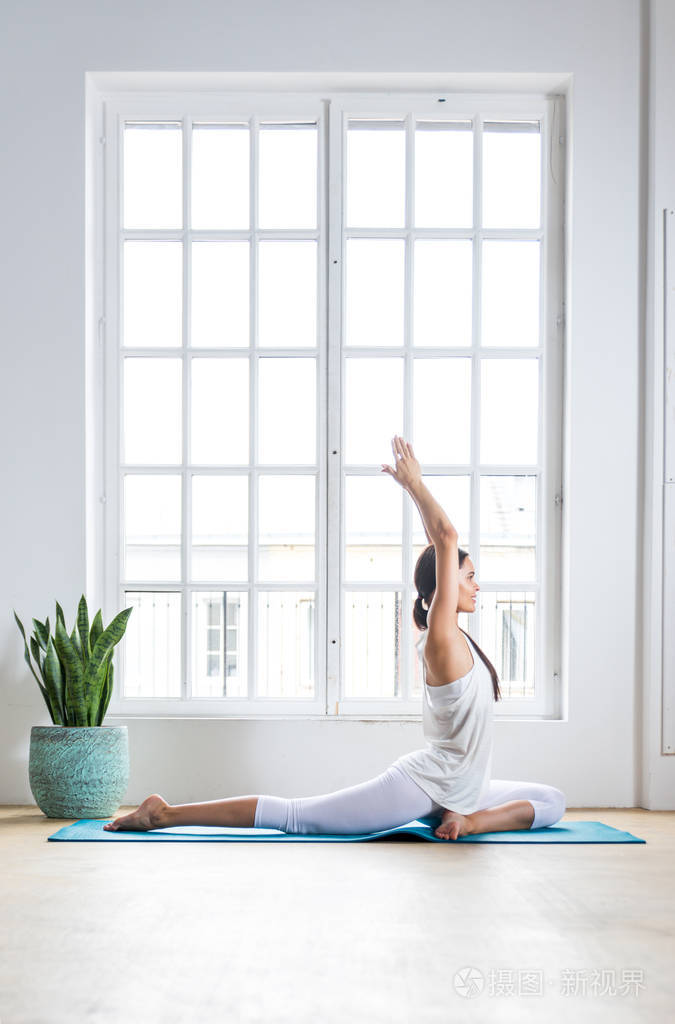 美丽的女孩在家里做训练和瑜伽在早上