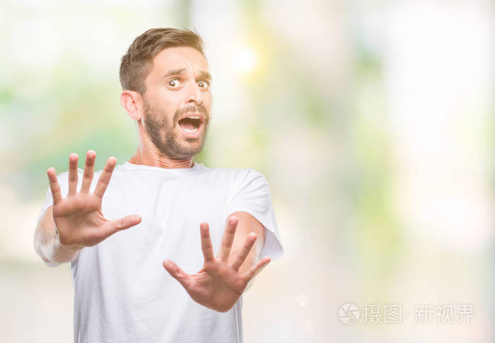 年轻英俊的男人在孤立的背景下害怕和恐惧的表情用手停止手势在震惊中