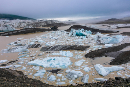 蓝色冰在暗藏的 Svinafellsjokull 冰川泻湖在巨大的 Vatnajokull 冰川的胳膊在南冰岛