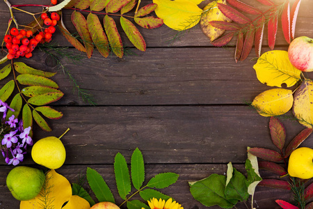 美丽的框架, 五颜六色的秋天树叶, 水果和花朵在棕色木质背景, 顶部的看法。复制空间