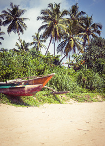 钓鱼与棕榈树在酒泉的热带海滩上的小船