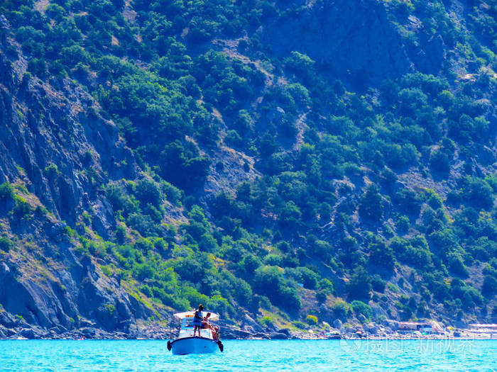 游客乘船出海游客们正躺在蓝海的小船上在群山的映衬下