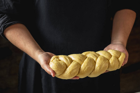 男面包师拿着面包的原始 challah 犹太面包