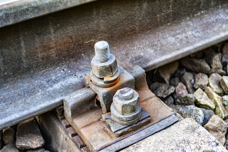 铁路轨道上安装钢轨的旧锈螺栓.轨道交通的可靠性照片