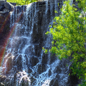 美丽的瀑布在阳光下, 许多美丽的水射流环绕着绿色森林