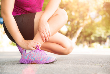 女子因脚踝受伤而行使。跑步运动损伤概念