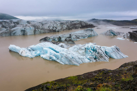 蓝色冰在暗藏的 Svinafellsjokull 冰川泻湖在巨大的 Vatnajokull 冰川的胳膊在南冰岛