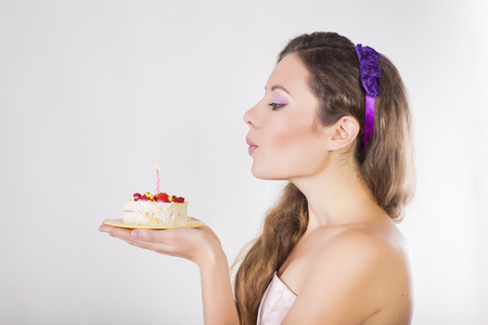 美丽快乐的女孩提出用蜡烛的生日蛋糕