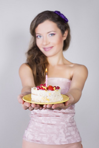 美丽快乐的女孩提出用蜡烛的生日蛋糕