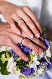 新娘和新郎的手躺在一束花上。从顶部的视图。婚礼