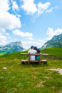 坐在木凳上的夫妇的后视图, 看着黑山杜尔米托尔地块上的山脉