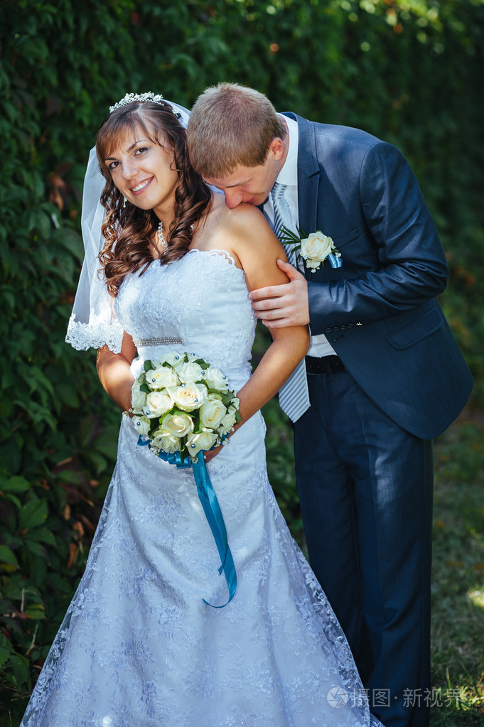 新婚夫妇,幸福的新婚夫妇在绿色公园深情相拥