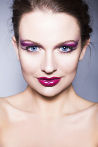 美丽的黑发女人，有创意化妆紫色眼影全是红红的嘴唇，蓝色的眼睛和卷曲的头发
